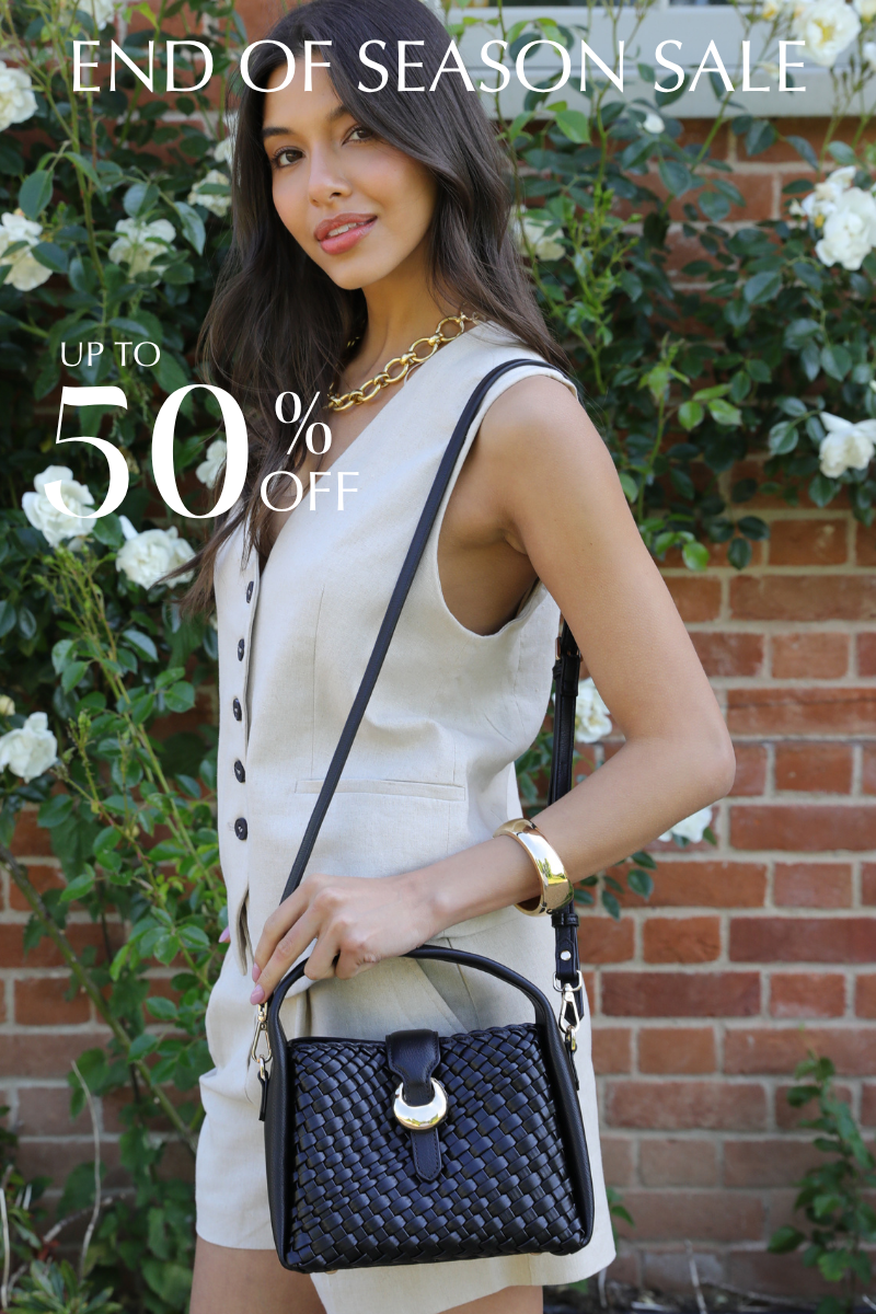 Woman in front of a garden wall with e black woven bag with text saying End of Season Sale up to 50% off 