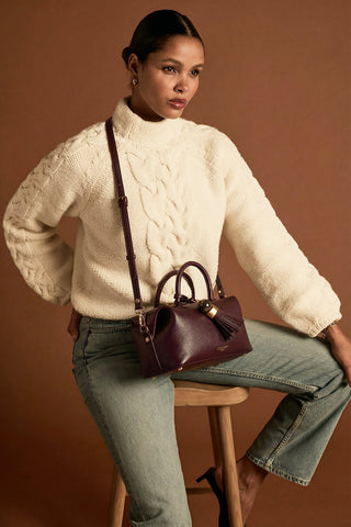 Female model wearing Alessia Black Cherry faux leather Bowler Tote by Luella Grey across her body using the detachable crossbody strap 