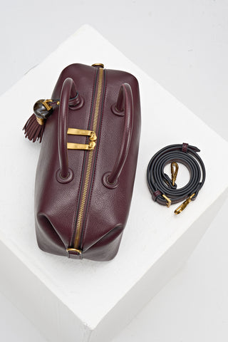 Birds-eye view of Alessia Black faux leather Bowler Tote by Luella Grey with matching detachable crossbody strap rolled up next to the bag