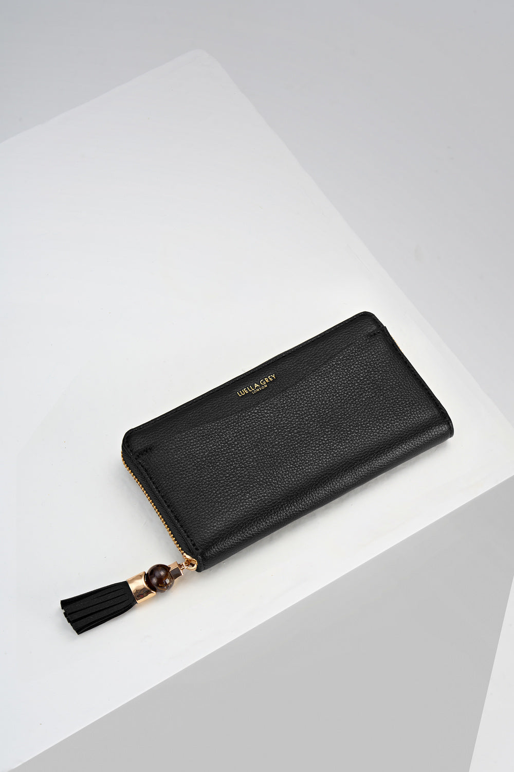 Overhead view of the front of Capriana Black faux leather Large Purse with mini Thames Tassel detail on the zip
