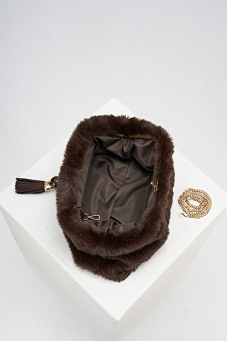 Overhead view of Indigo Chocolate faux fur Oversized Clutch open showing the inside and covered gold frame clasp opening and the gold metal chain next to the bag