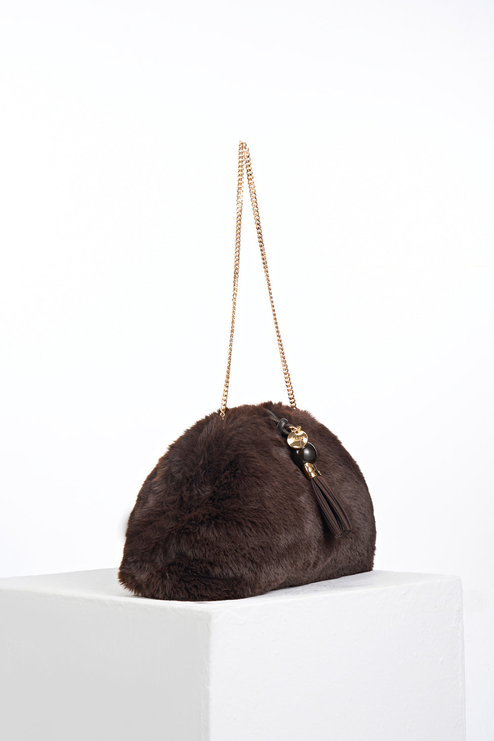 Side view of Indigo Chocolate faux fur Oversized Clutch showing the gold clasp closure and detachable gold metal chain shoulder strap