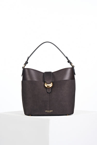 Front of Indra Chocolate recycled suede and faux leather Bucket Crossbody showing the Signature Molten Metal Cannon Street Clasp closure on the front slip in suede pocket