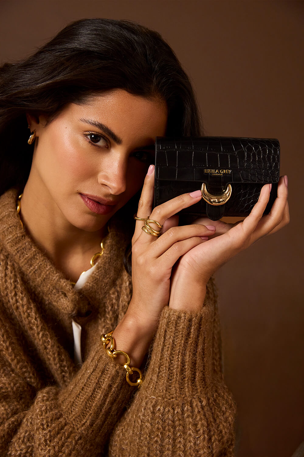 Female model holding Letitia Black Crocodile print faux leather Medium Purse in two hands