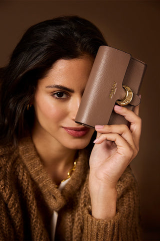 Female model holding Letitia Fawn faux leather Medium Purse in one hand