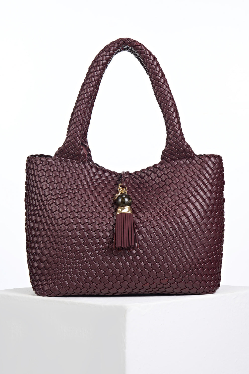 Front view of Saskia Black Cherry faux leather Woven Tote with Thames Tassel closure detail