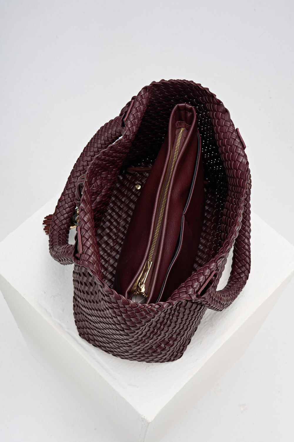 Overhead view of the inside of Saskia Black Cherry faux leather Woven Tote with internal detachable zipper pouch