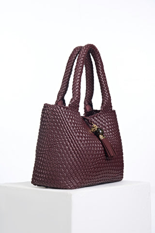 Side view of Saskia Black Cherry faux leather Woven Tote with Thames Tassel closure detail